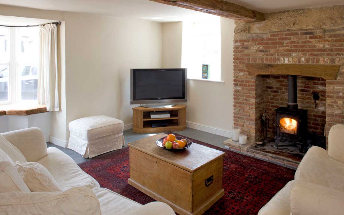 Morton House TV room with comfy sofas and wood stove